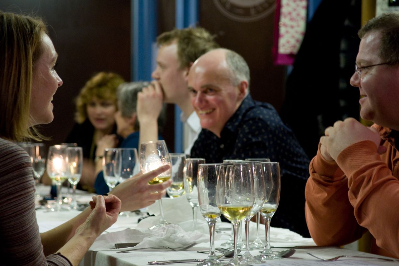 a woman talks to two men and a woman at a restaurant table