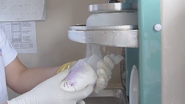 a person in white gloves opening an oven door