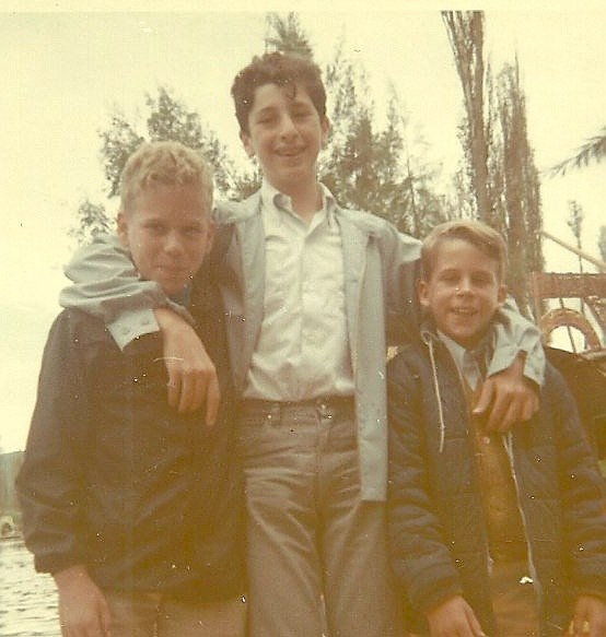 three boys posing for the camera on a boat