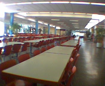 a blurry image shows a bunch of tables in the middle of a room