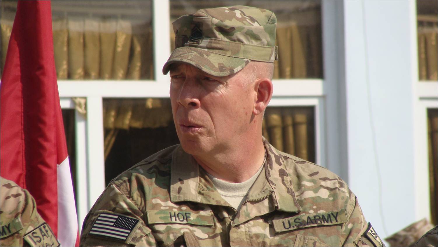 a close up of a person in a uniform near a flag