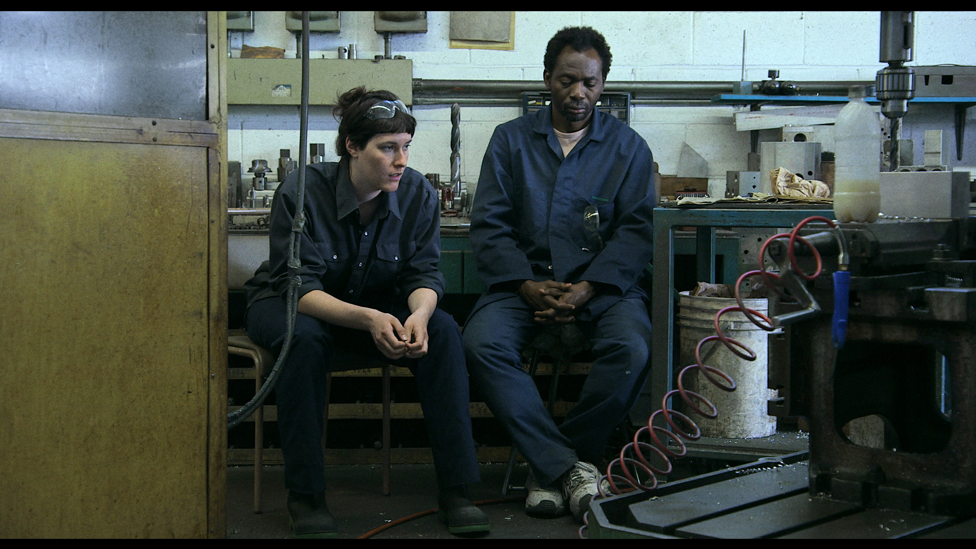 two people sitting inside of an industrial workshop