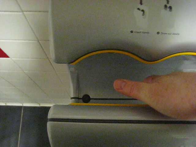 a hand that is pressing a on on a water heater