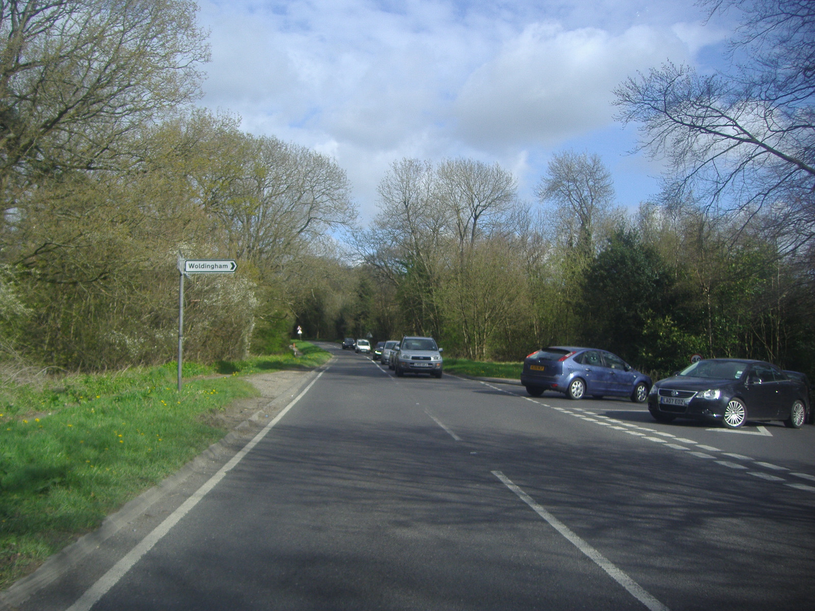 an image of a country road with some cars parked on it