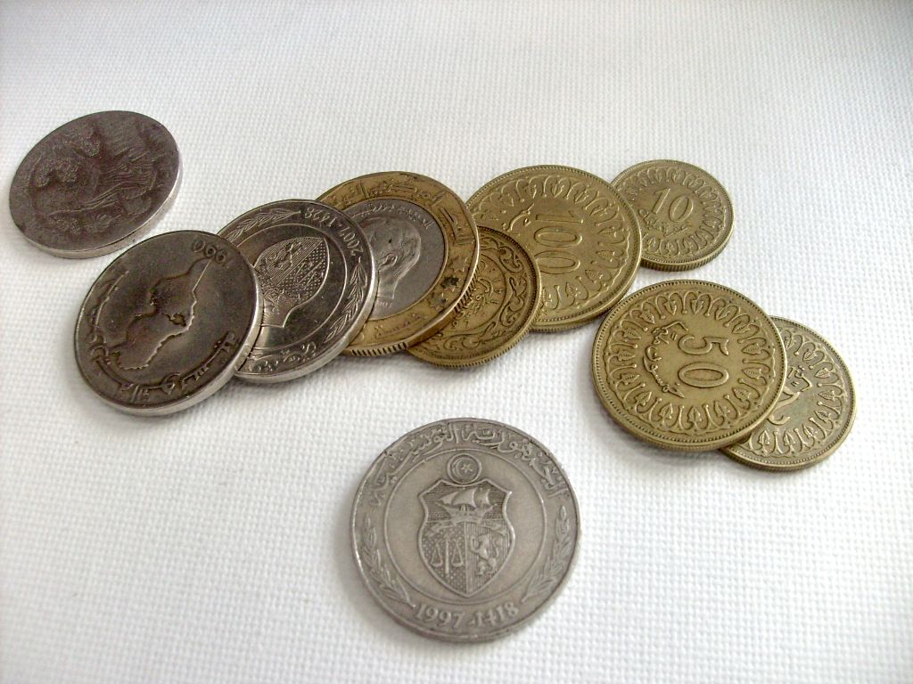 five different coins sitting on top of a white table