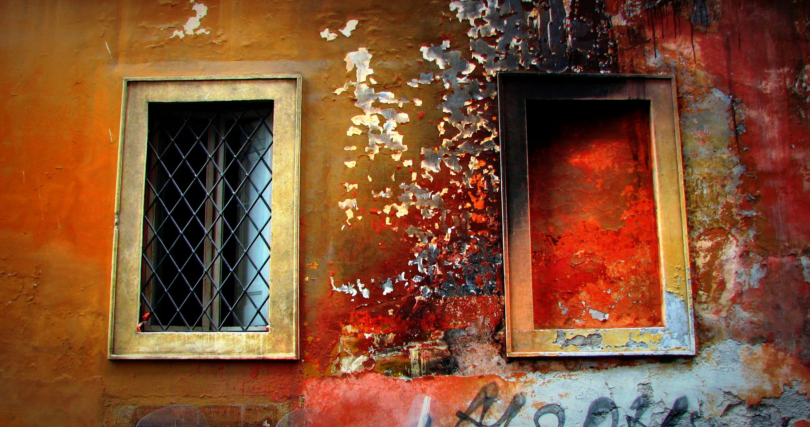 two windows on the side of an old building