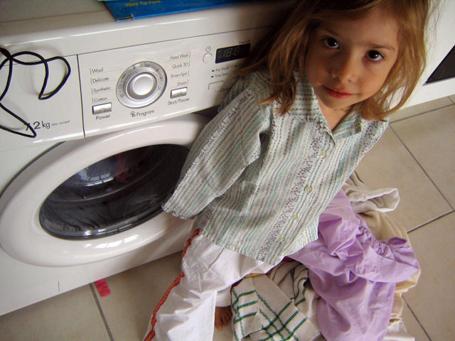 girl in front of a washing machine wearing clothing