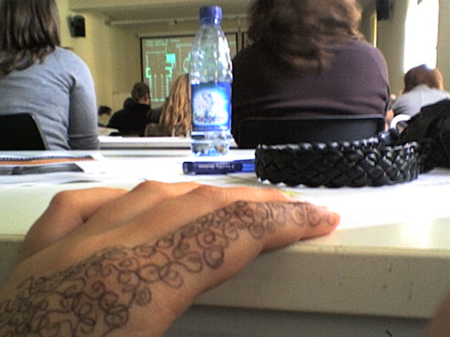 a person's arm in a tattoo design and a table with people