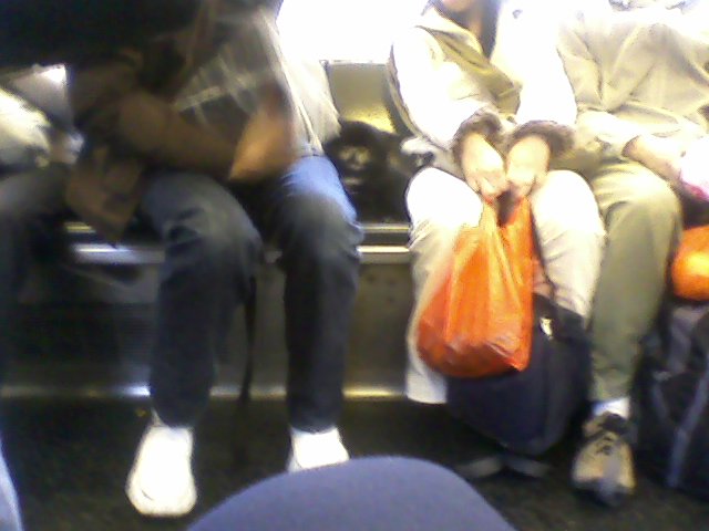 the man sits on a bus with his purse in his hand