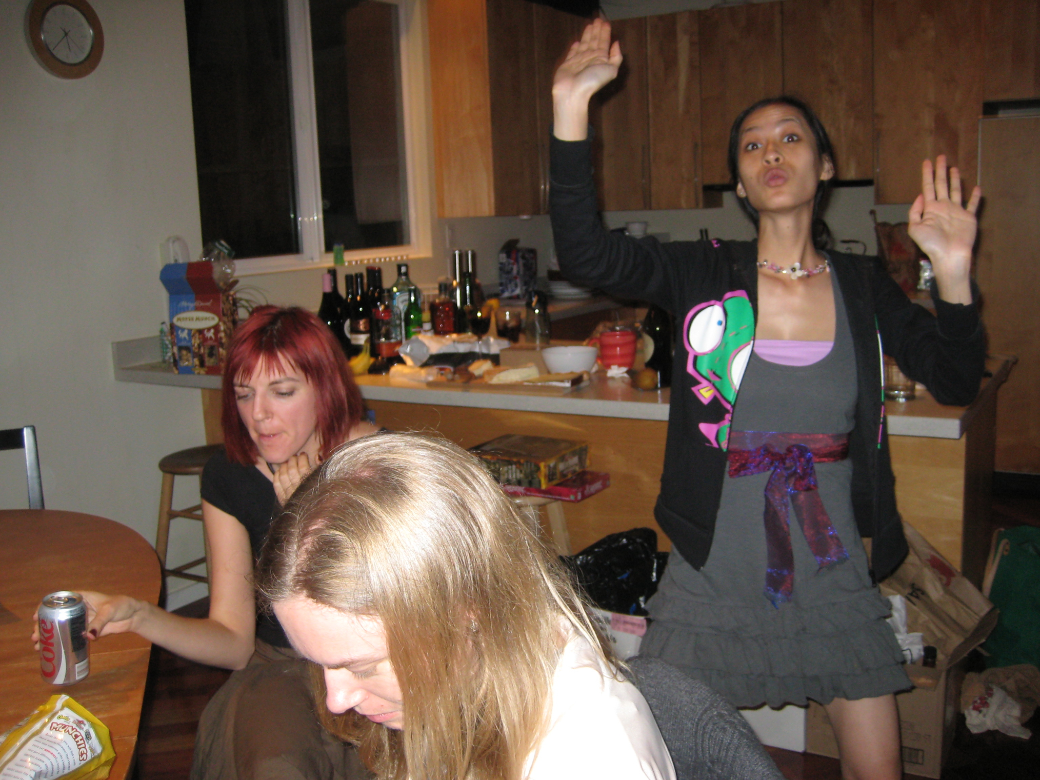 three women are in the kitchen together with their hands raised