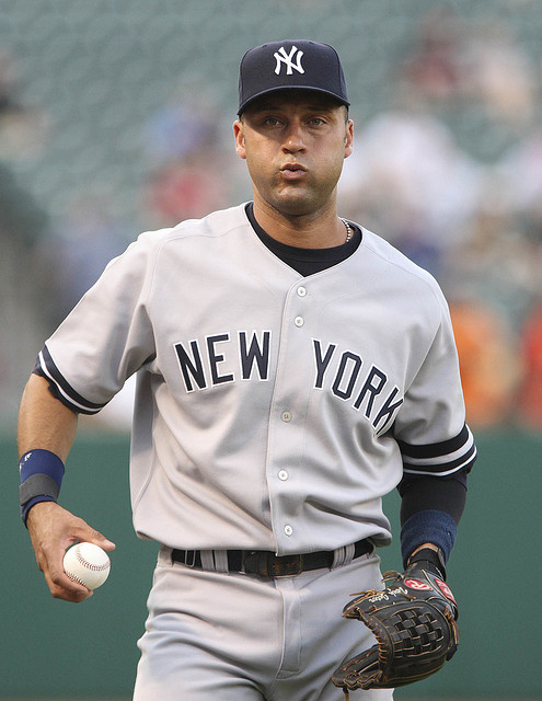 a man in a new york yankees baseball uniform holding a baseball