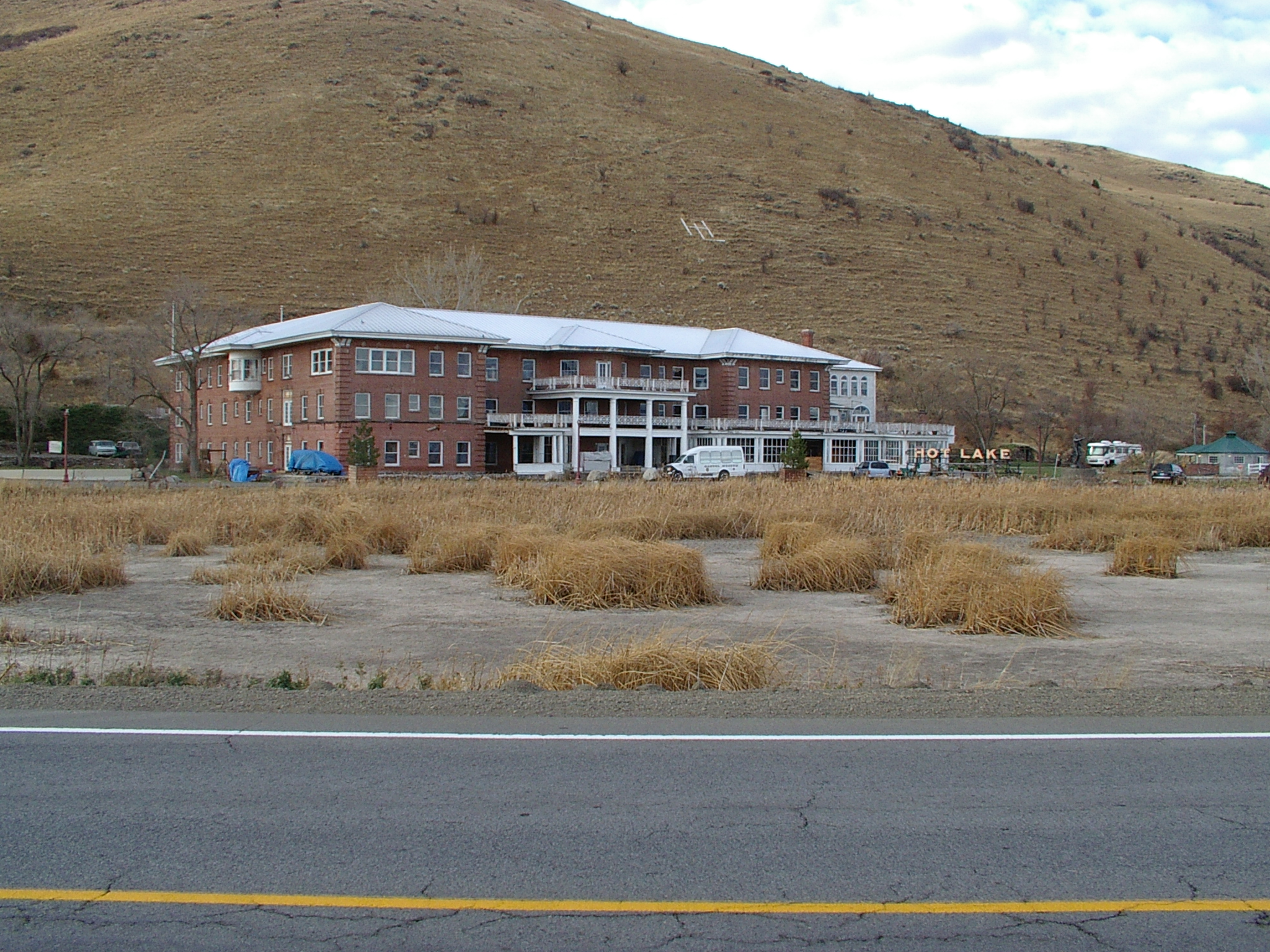 a red brick building in the midst of dry grass