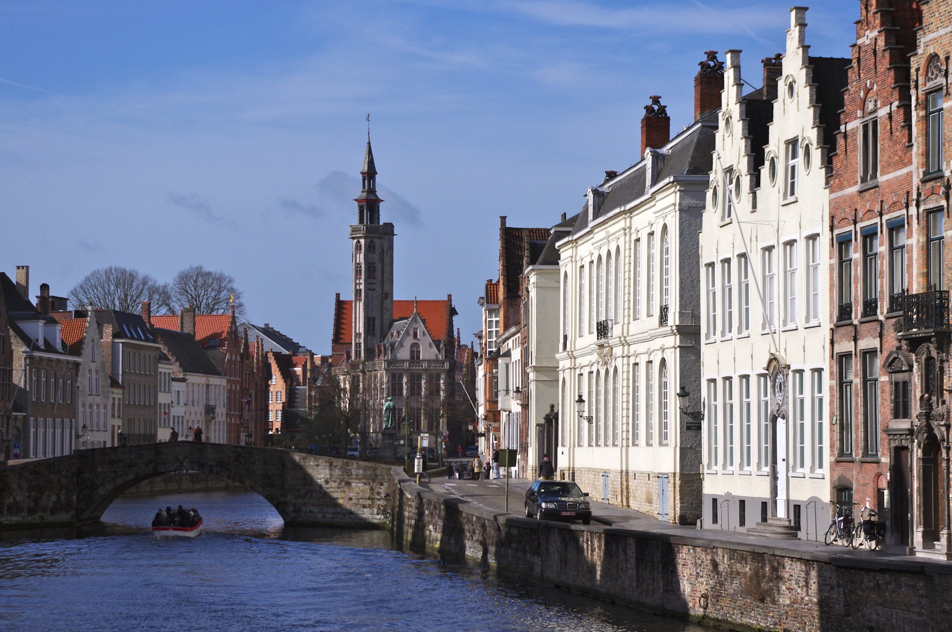 a small boat sails down a small river through some town buildings