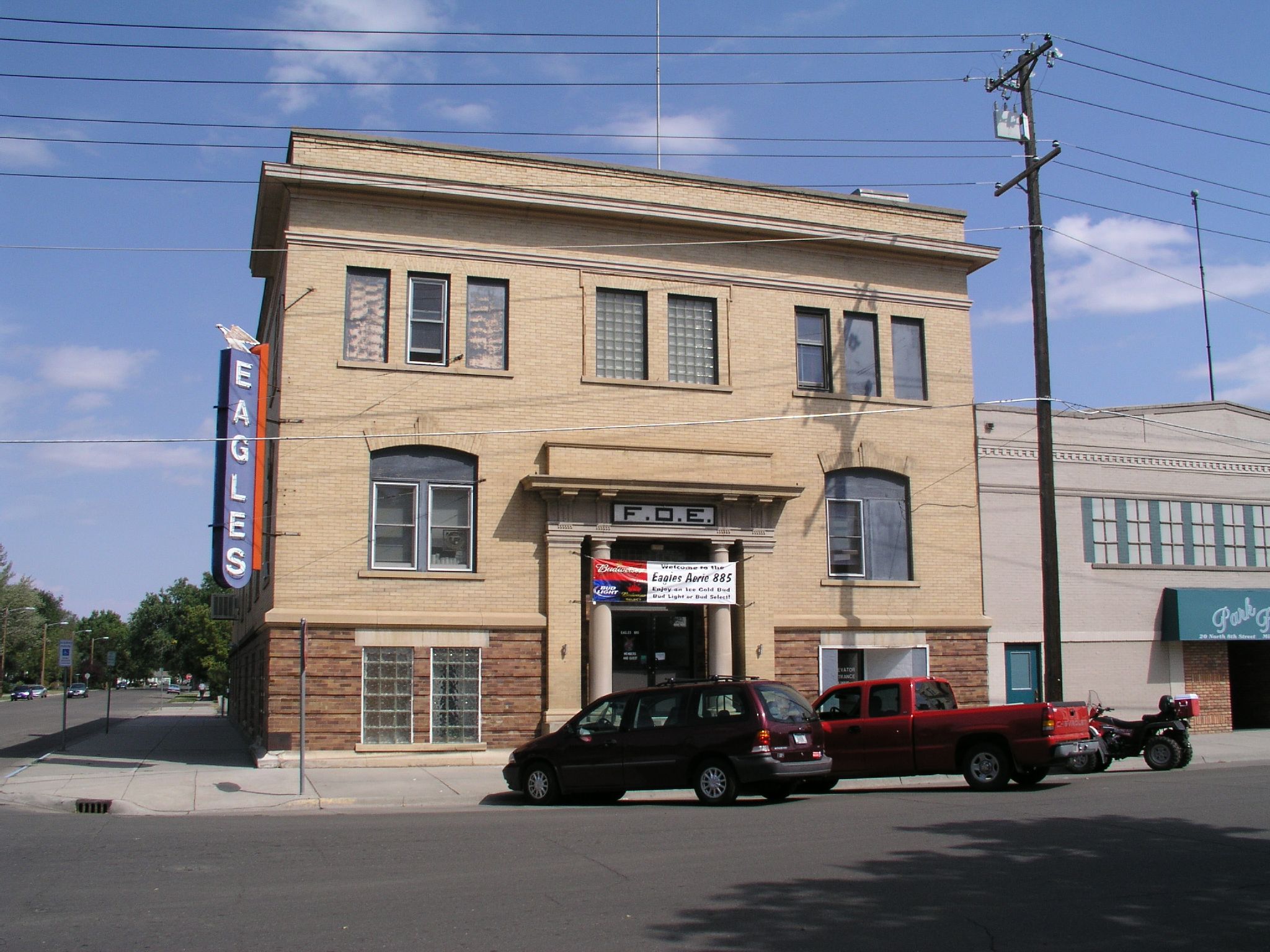 two vehicles are parked outside a large building