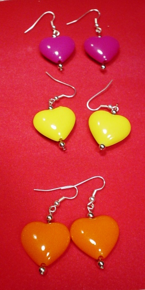 heart earrings on a red table with yellow and pink earwires