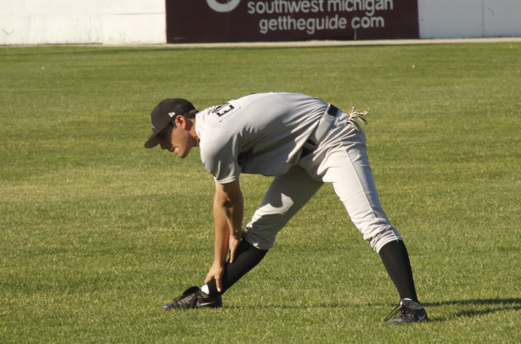 a baseball player bending down in the outfield