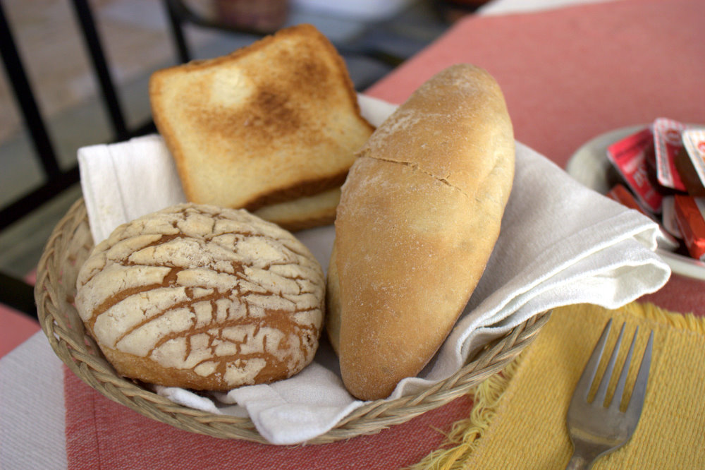 a basket filled with assorted bread and muffins