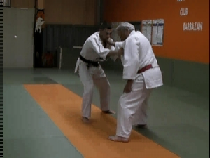 two men in white karate uniforms in a gym