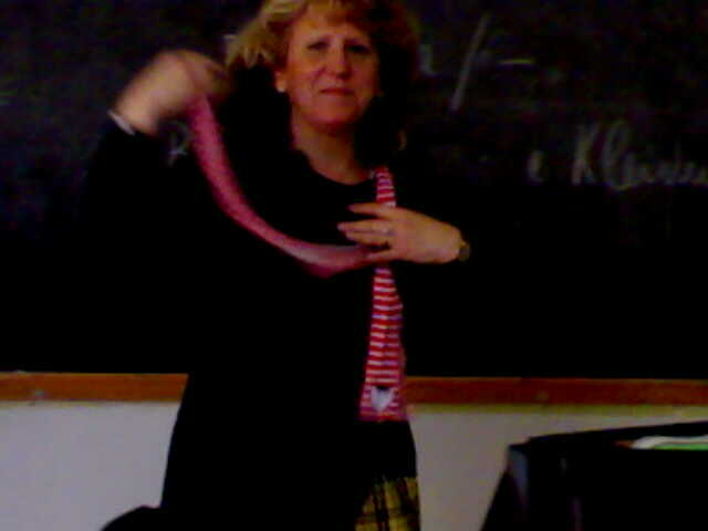 a woman is putting a tie on her neck