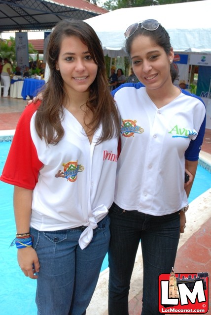 two young women standing near an aqua pool