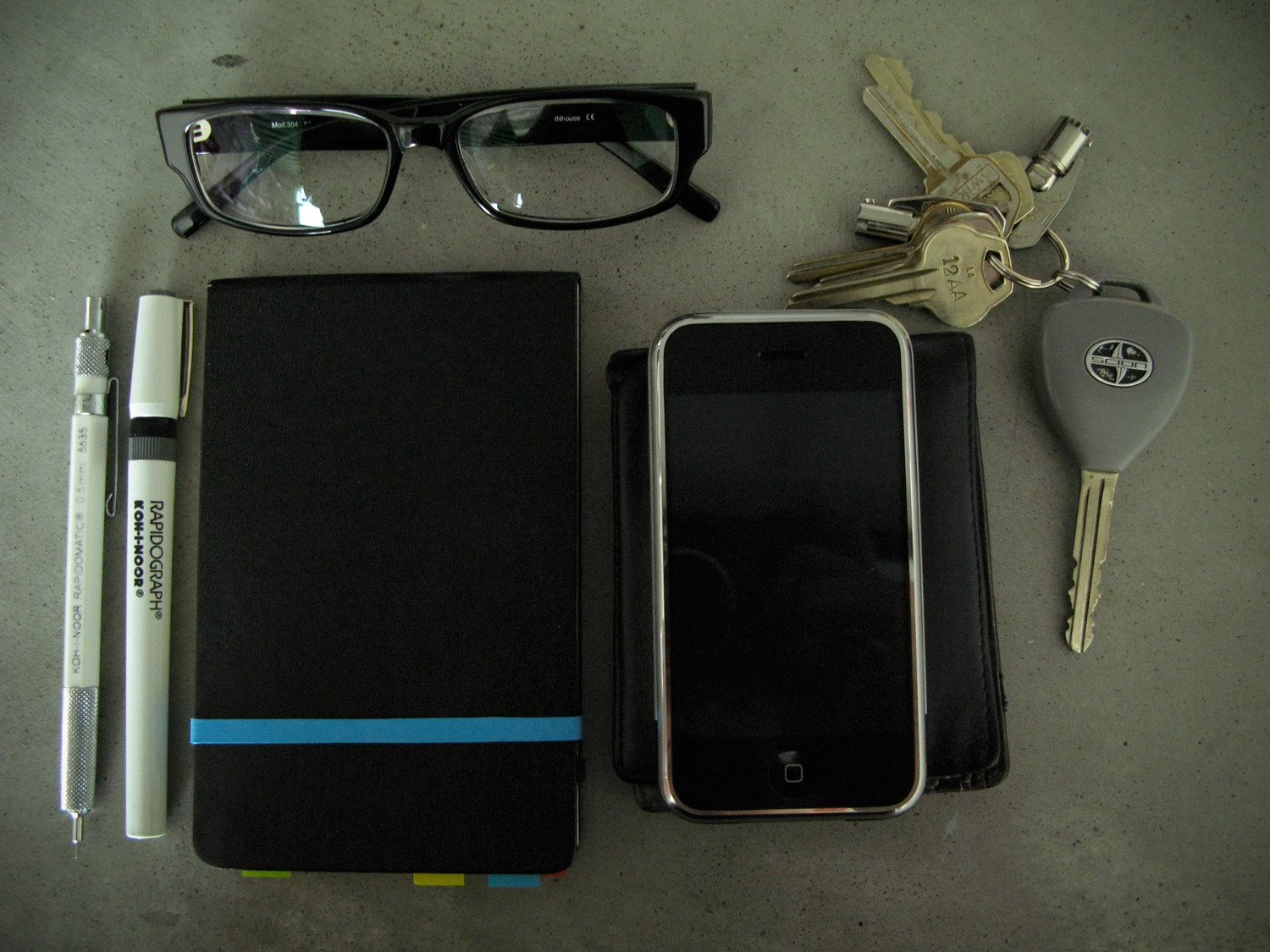 the contents of a travel bag including keys, wallet and cell phone