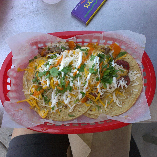 a basket filled with tacos covered in cheese