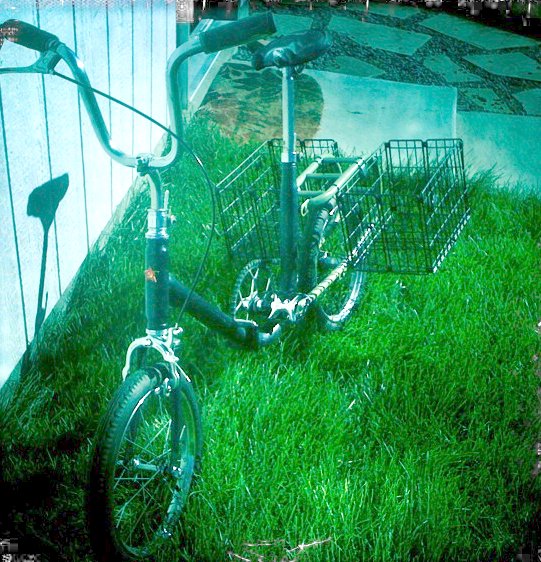 a green bike is sitting in the grass