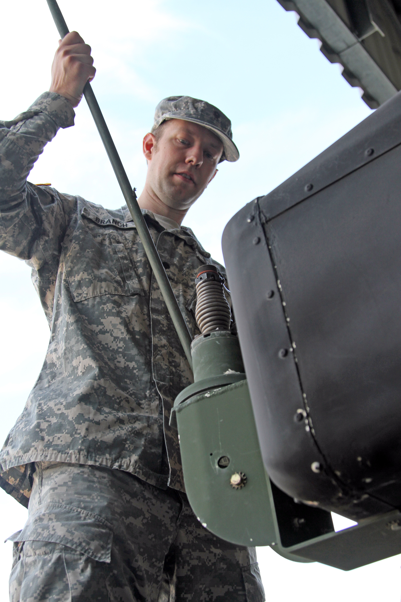 a man in camouflage stands with an object