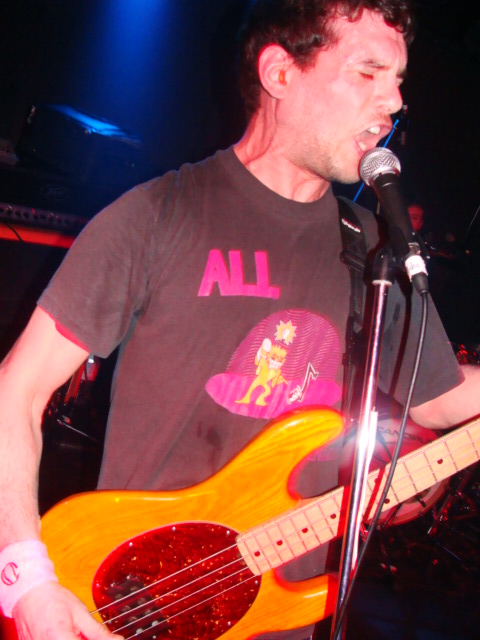 a man playing guitar in front of microphone