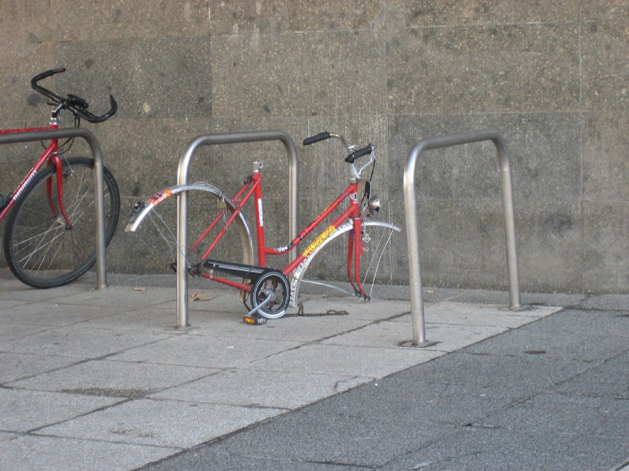 bicycles locked in front of barriers in a city