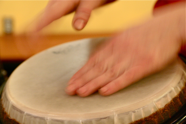 a hand is pressing ons on the drum