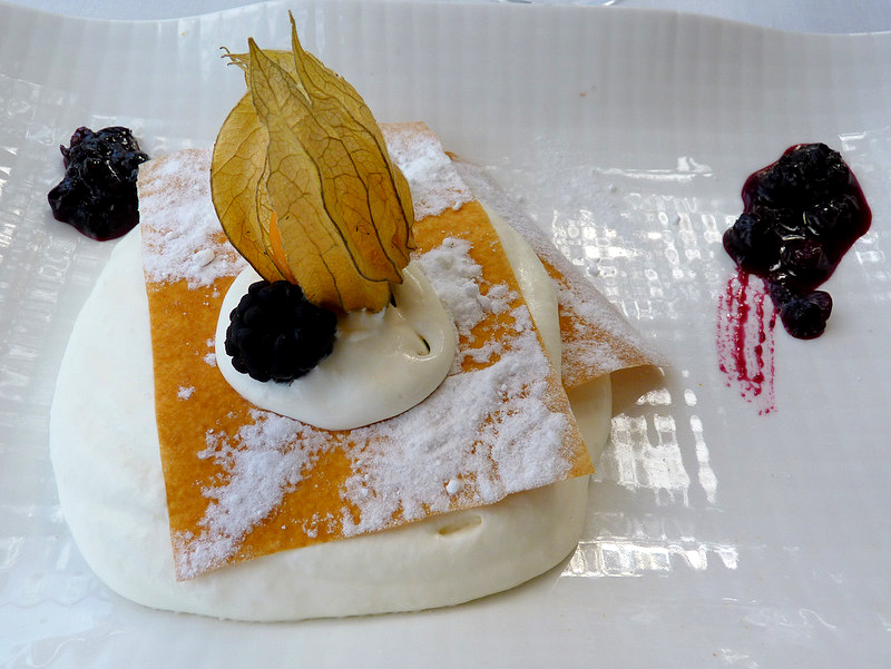 a piece of bread is topped with jelly and blackberries