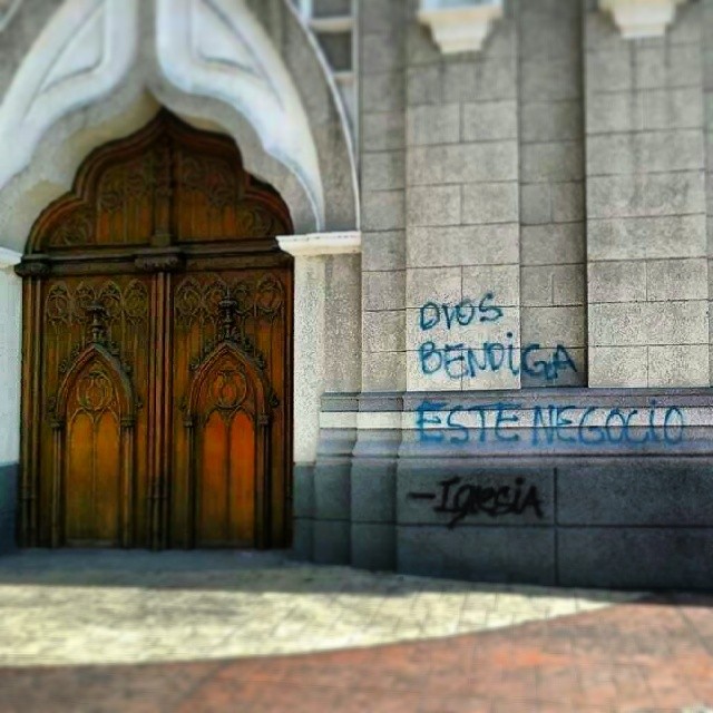 an arched wooden door with graffiti on it