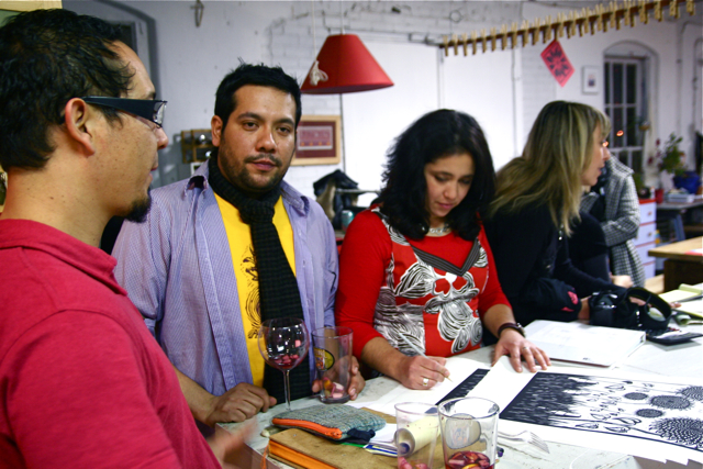 a group of people standing around a table working on crafts