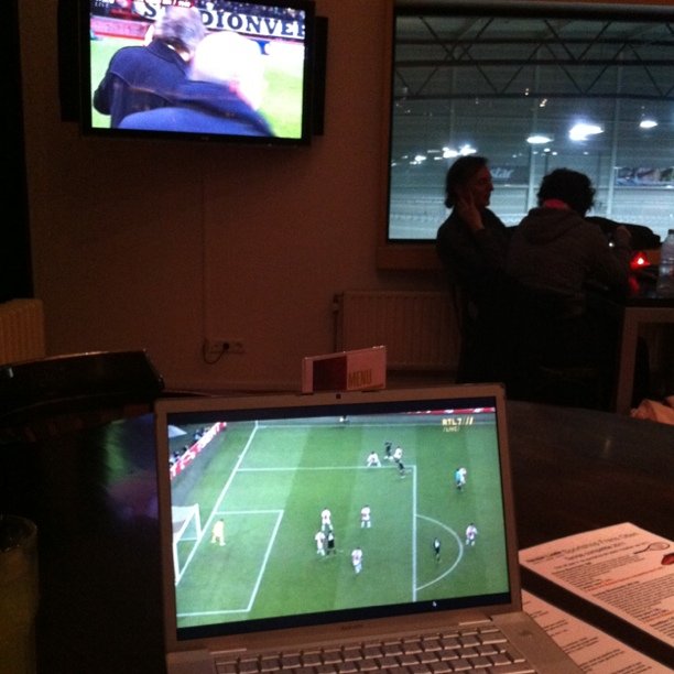 a person is watching a soccer game on his laptop