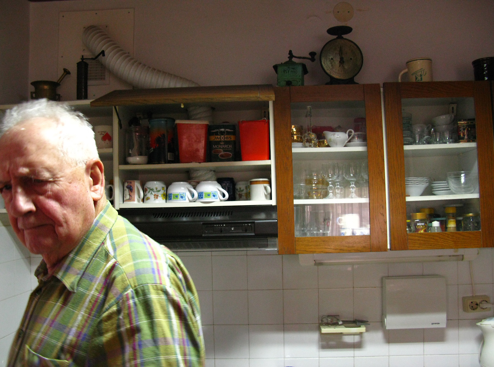 an elderly man looking at the camera in the kitchen