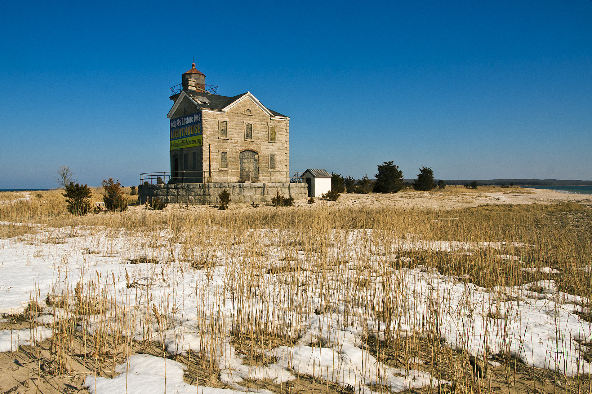 an abandoned church standing next to a dirt field
