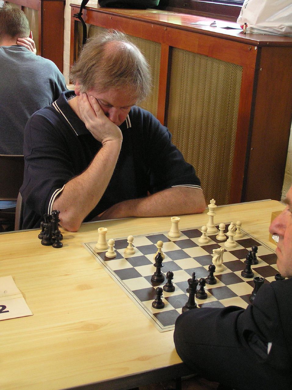 a man sitting at a table with chess