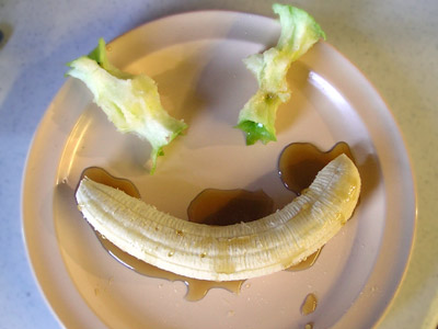 banana with chocolate sauce in the shape of smiley face