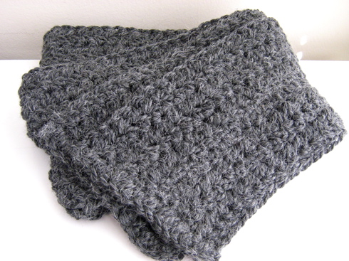 a gray knitted blanket sitting on top of a table