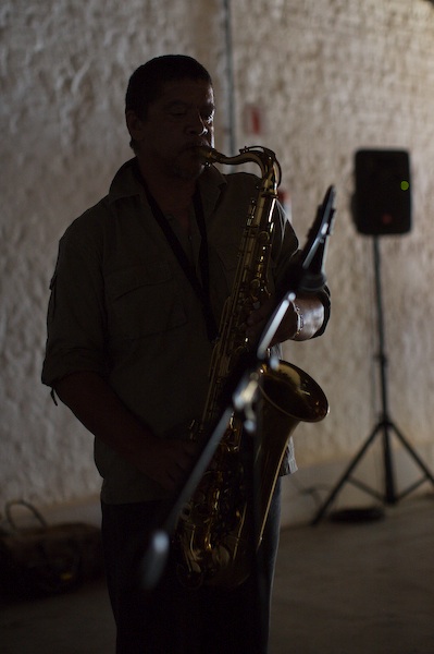 man playing a saxophone in front of a projector