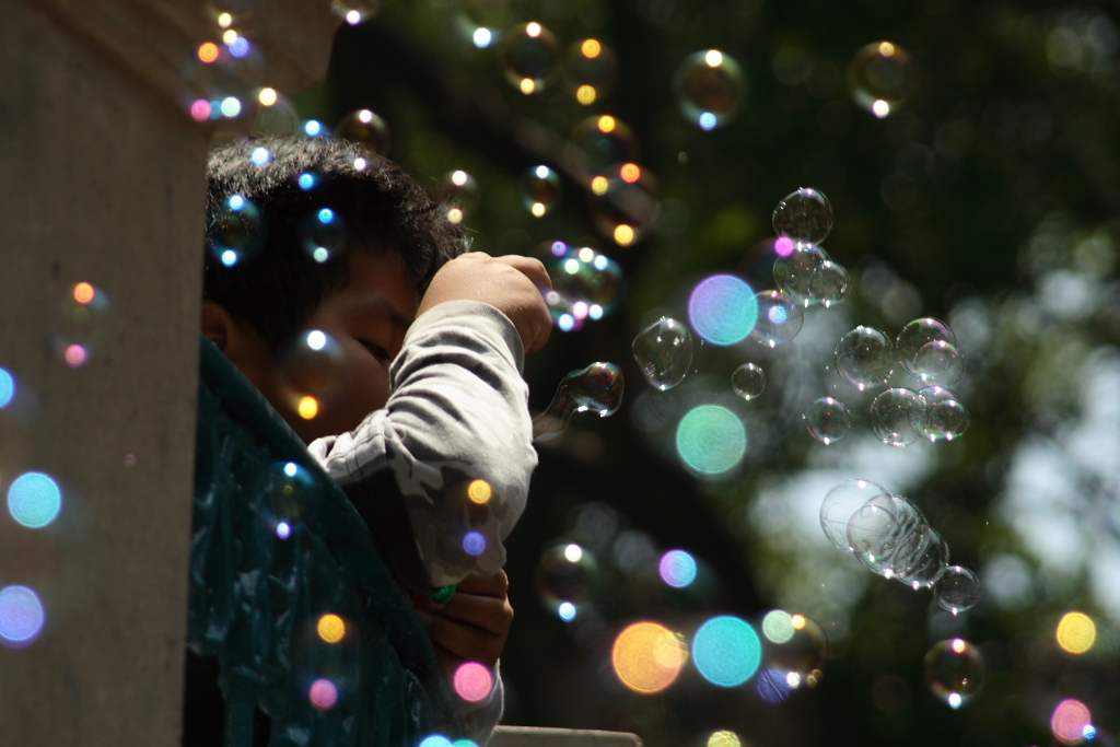 a child is holding his hand out for bubbles
