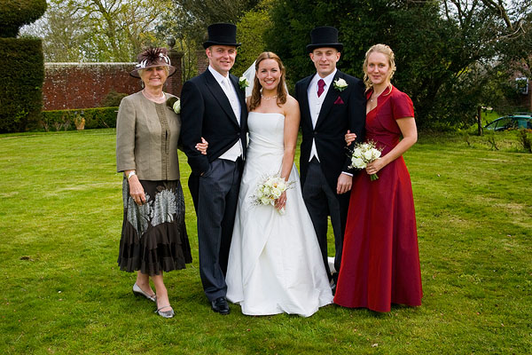 a bride and groom with their three family members