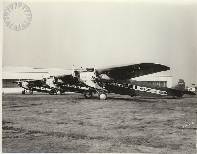 three black airplanes with propellers sitting outside a hangar