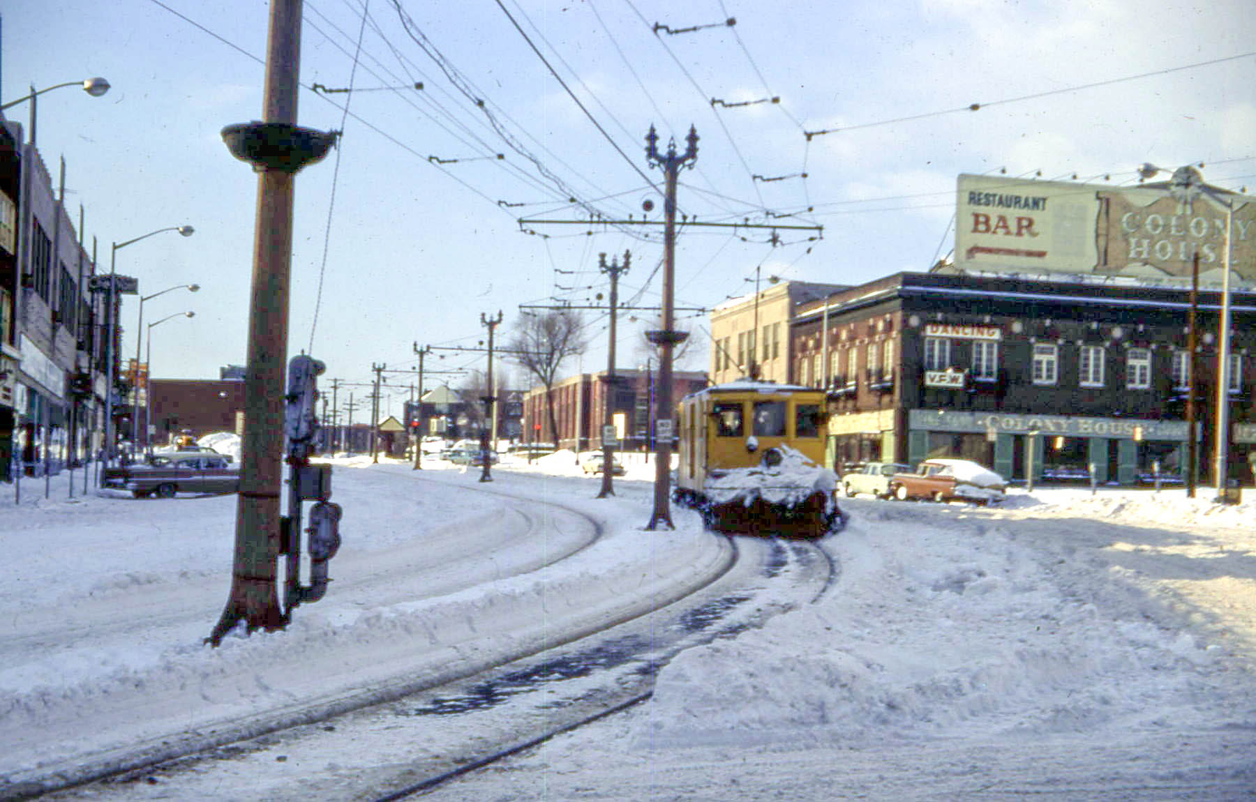 a street that has a bunch of cars and cars driving down it in the snow