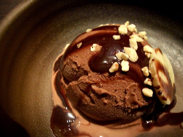 a dessert with a chocolate sauce and nuts on top