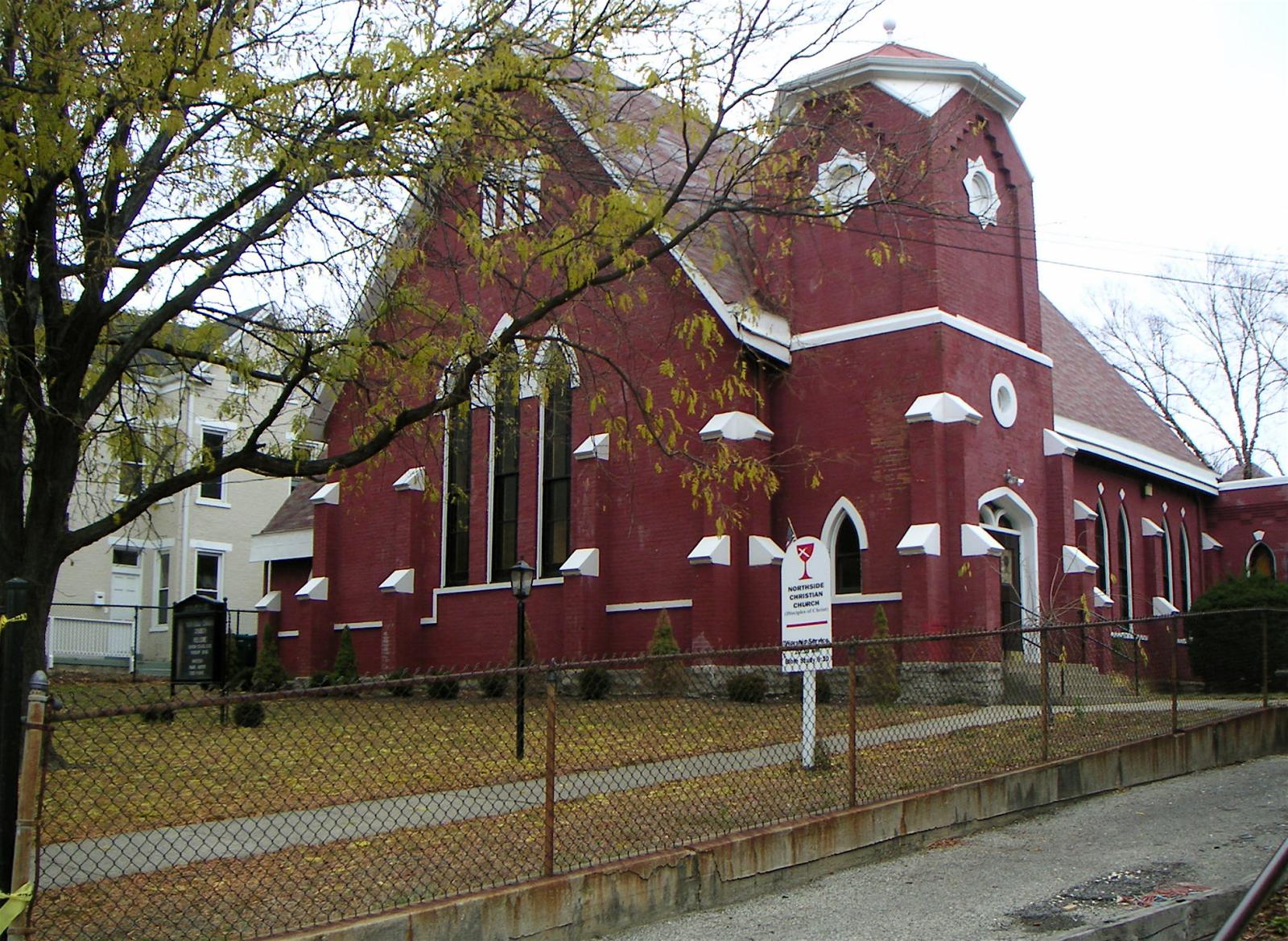 an older red building with two white doves on the steeple