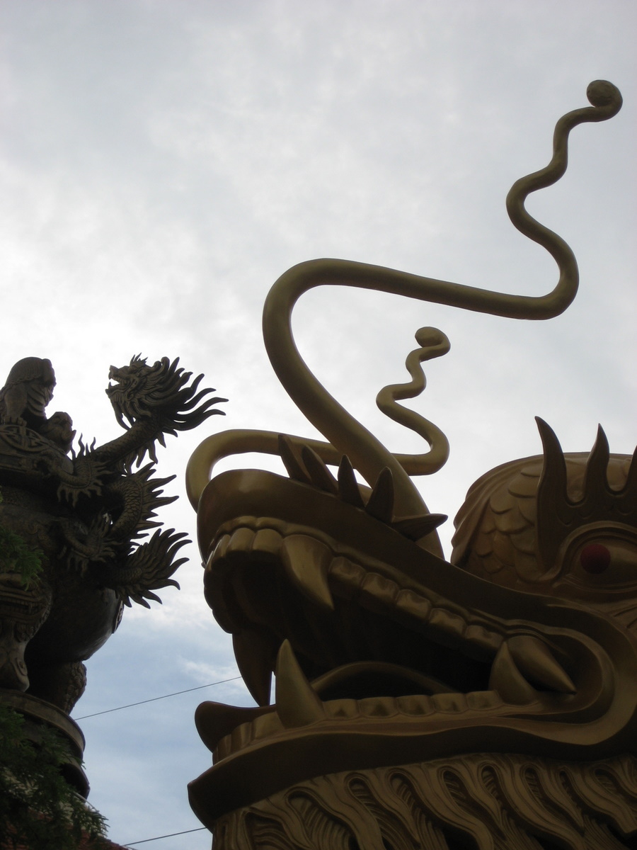 a statue of a large, intricate dragon and a smaller demon
