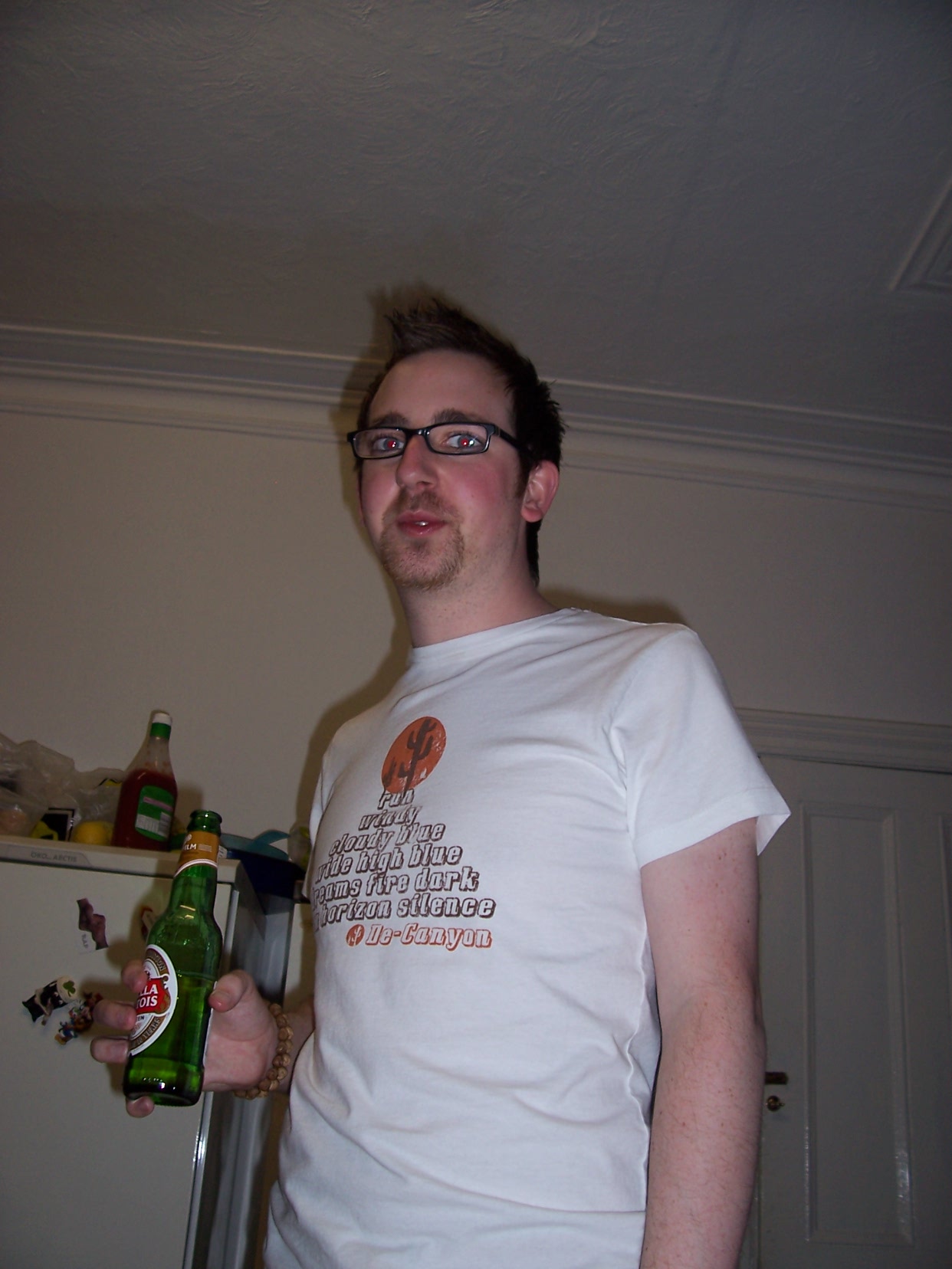 a man holding onto some beer bottles while wearing a t - shirt