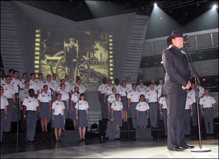 an old man is performing on stage with a bunch of soldiers in the background